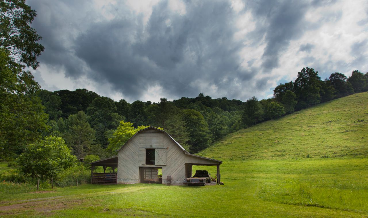 Old wooden barn in a green mountain meadow